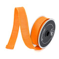 Orange dupioni wired ribbon unrolled on spool for bow making and fall crafts.